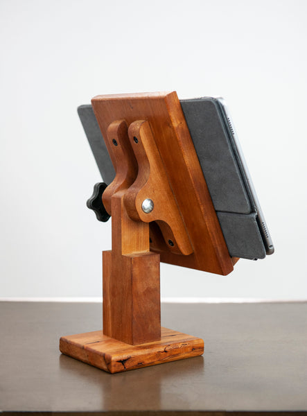 Adjustable wood tablet stand shown at an angle from the back with an iPad on the stand on a white background.