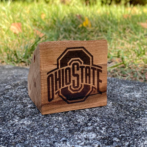 Small live edge wood block with The Ohio State University (OSU) Sport Logo Laser Design on a grass background. 