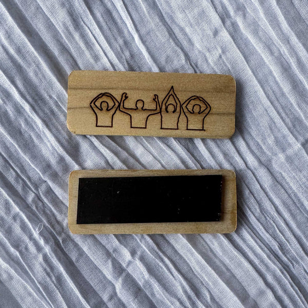 Two wooden block magnets with engraved OSU Spirit design on a textured fabric background