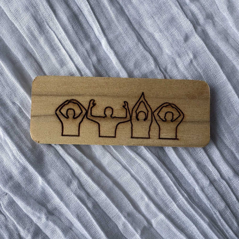 Wooden block with engraved OSU Spirit People on a textured fabric background