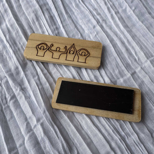 Two wooden block magnets with engraved OSU Spirit design on a textured fabric background