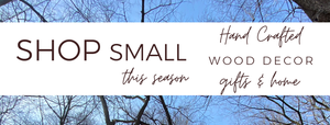 Text Banner with brown text: Shop Small this season. Background with blue sky and brown trees without leaves. Hand crafted wood decor gifts and more.