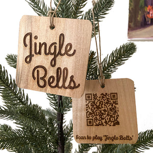 Laser engraved wood ornaments made from fallen wood. Christmas Carol Ornaments one with Jingle Bells and the other with a QR Code scan to play the song Jingle Bells.