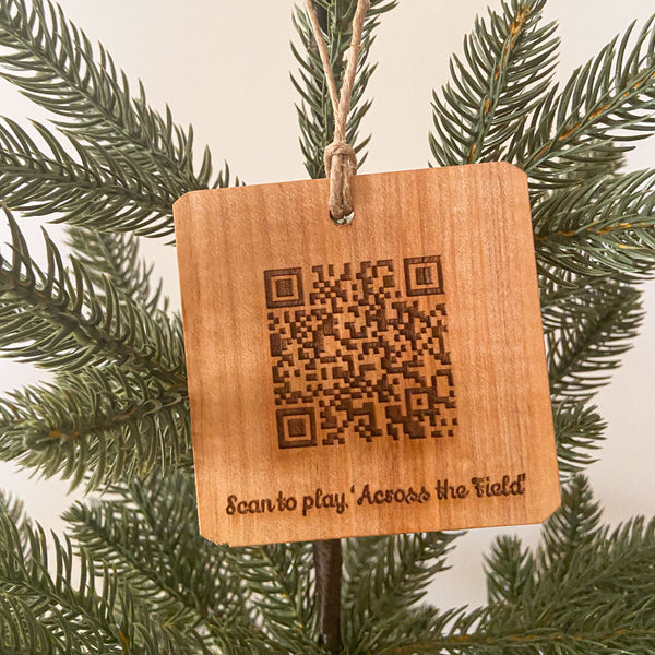 Laser engraved wood ornament with  QR Code to scan and play OSU Across the Field on pine tree background.