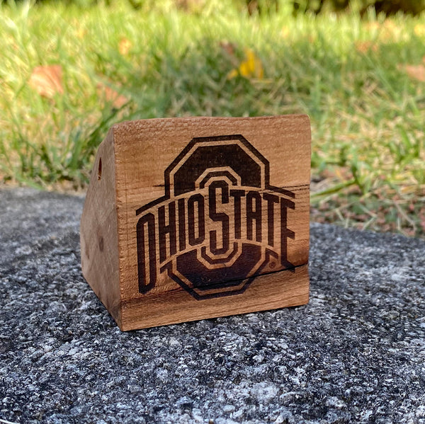 Small hand cut wood block with official The Ohio State University sport logo laser design on a grass background. Licensed by OSU gift.