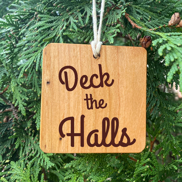 Deck the Halls Wood Ornament on pine tree background