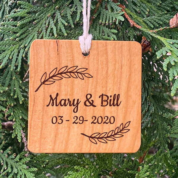 Wood Ornament laser engraved text Mary & Bill 03-29-2020 on pine tree background.