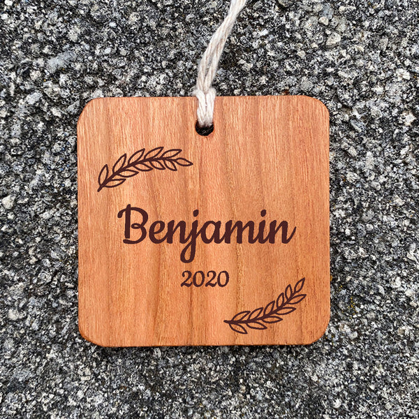 Wood ornament with Benjamin 2020 on a concrete background.