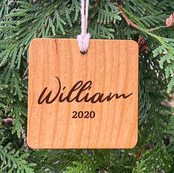 Wood ornament with William 2020 on a pine tree background.